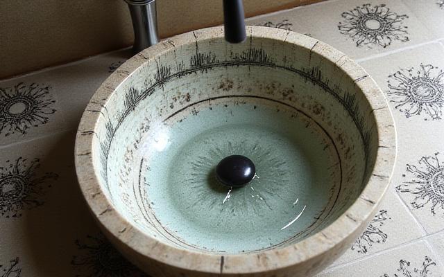 Artisanal hand-etched ceramic basin with unique patterns and matching tiles, inspired by calligraphy